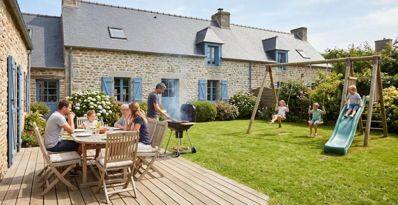 Jardin privatif d'une maison de vacances bretonne avec terrasse en bois, salon de jardin, barbecue et espace de jeux pour enfants